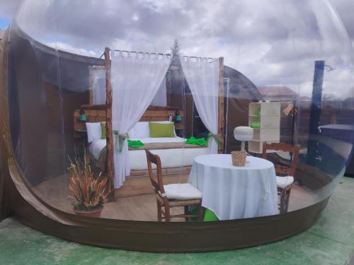 Zimmer mit einem Bett und einem Tisch in einem Zelt in der Unterkunft COSMOVEROS, Bubble Experience in Pedraza