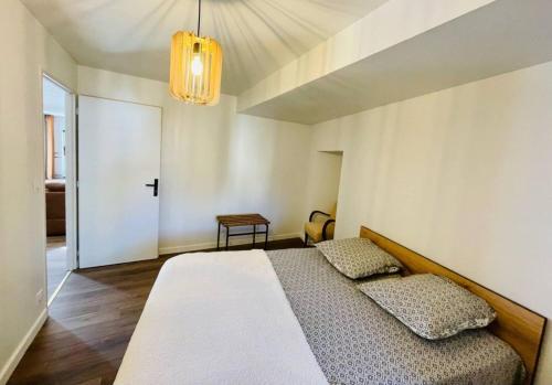 um quarto com uma cama e um lustre em Residence les isards em Formiguères