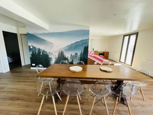 uma sala de jantar com uma mesa de madeira e cadeiras em Residence les isards em Formiguères