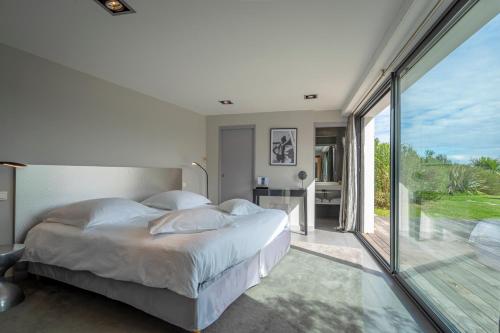 une chambre avec un grand lit et une grande fenêtre dans l'établissement Lafitenia Resort, à Saint-Jean-de-Luz