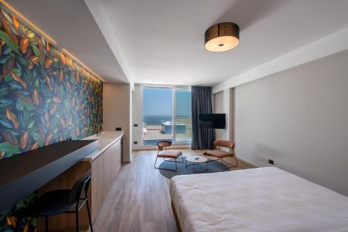 a hotel room with a bed and a view of the ocean at Hotel Sporting Riccione in Riccione