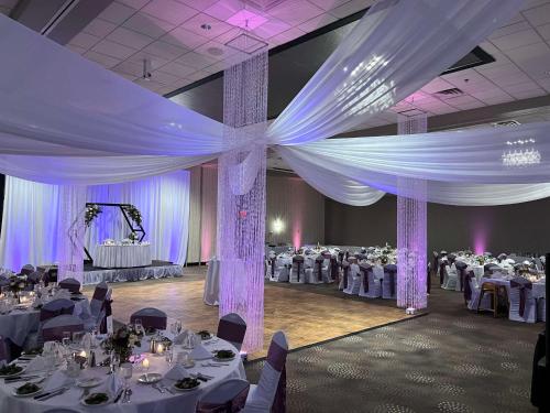 a banquet hall with white tables and purple curtains at DoubleTree by Hilton Bloomington in Bloomington