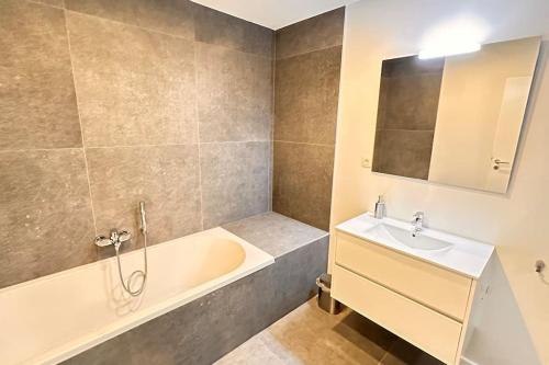 un bagno con vasca e lavandino di Escapade Ardenne: 16 pers a Esneux