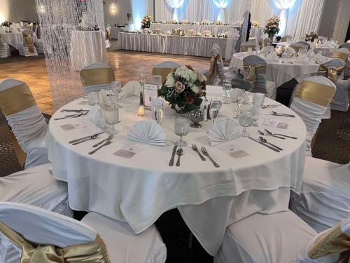 a table set up for a wedding with white tables and chairs at DoubleTree by Hilton Bloomington in Bloomington