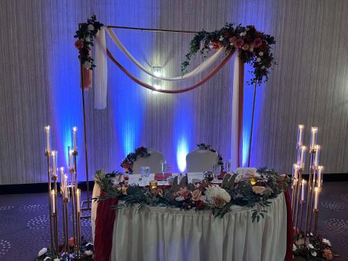 a table with flowers and candles in front of a stage at DoubleTree by Hilton Bloomington in Bloomington