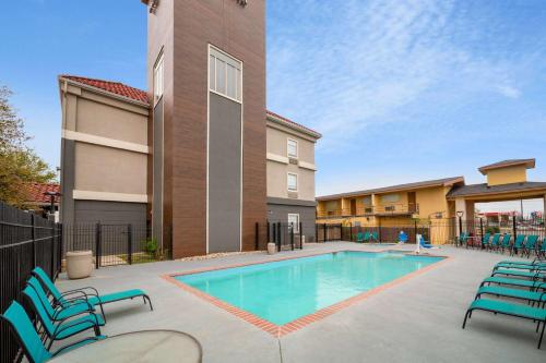 a swimming pool with chairs and a building at La Quinta by Wyndham New Braunfels in New Braunfels