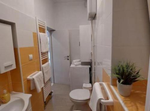 a white bathroom with a toilet and a sink at Chill apartment in Dubrovnik