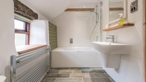 a white bathroom with a sink and a bath tub at Old Boswednack a rural retreat gem On the idyllic coast of Zennor to St Ives. Summer house garden parking for two cars and free WiFi. in Zennor