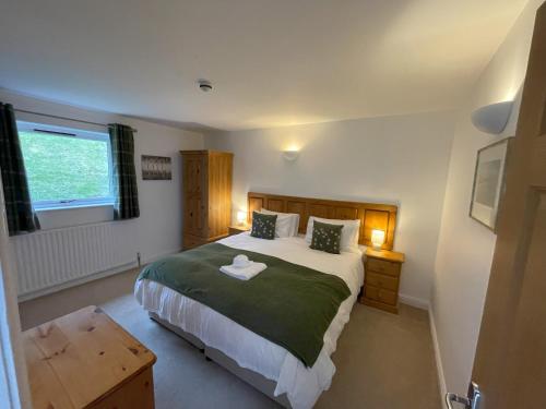 a bedroom with a large bed and a window at Sladen Lodge in Hathersage