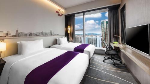 a hotel room with two beds and a large window at Hilton Garden Inn Hong Kong Mongkok in Hong Kong