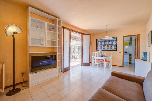 a living room with a couch and a tv and a table at Cinzia Apartment Front Beach - Happy Rentals in Sirmione
