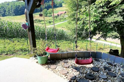 dwa huśtawki w ogrodzie z kamieniami w obiekcie House in Nature - Happy Rentals w mieście Sveti Križ