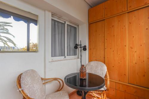 een kamer met een tafel, 2 stoelen en een raam bij 015 - Thailandia I 001 - comfortHOLIDAYS in Santa Pola