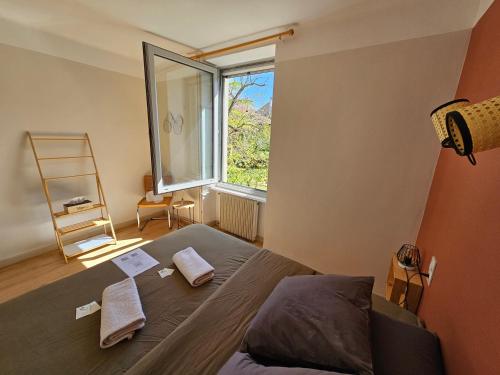 a bedroom with a bed and a large window at Chambre d'hôtes Les Berges de l'Aude in Puicheric