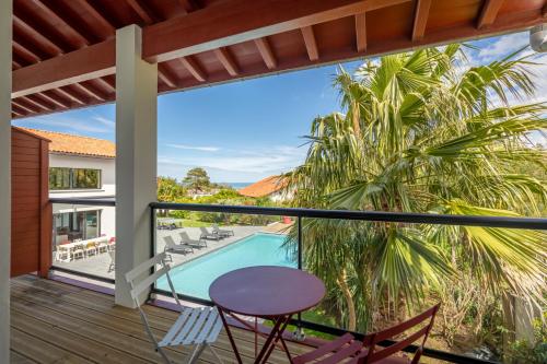 d'un balcon avec une table et des chaises, ainsi que d'une piscine. dans l'établissement Lafitenia Resort, à Saint-Jean-de-Luz