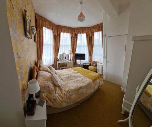 a bedroom with a large bed in a room with windows at The Chantry hotel in Dronfield