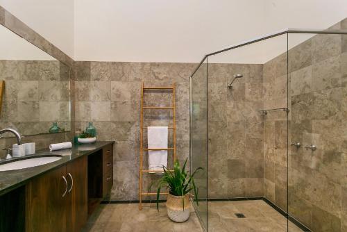 a bathroom with a shower and a sink at Warung Guest House Byron Bay in Byron Bay