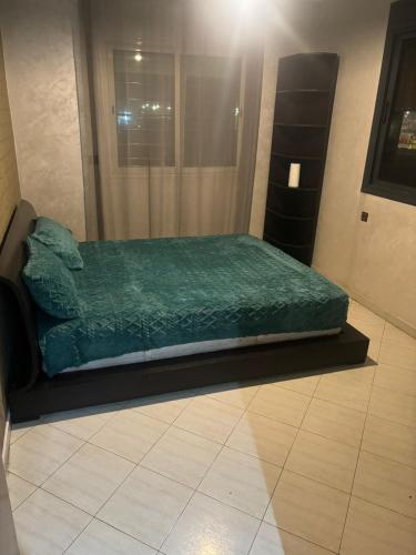 a bed in a room with a green blanket at Appartement in Casablanca