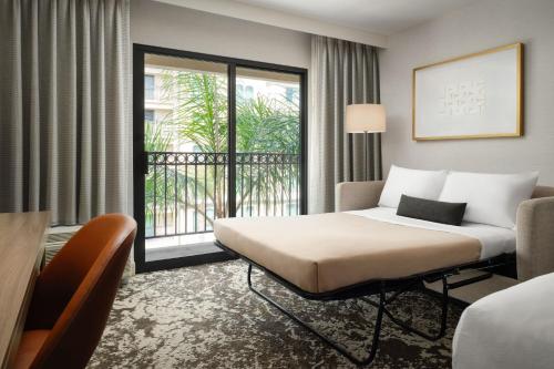 a hotel room with a bed and a balcony at Courtyard by Marriott Los Angeles Pasadena Old Town in Pasadena