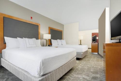 a hotel room with two beds and a flat screen tv at SpringHill Suites by Marriott Houston Brookhollow in Houston