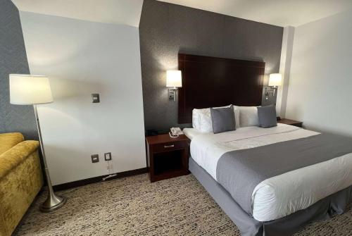 a hotel room with a large bed and a couch at La Quinta by Wyndham Reynosa in Reynosa