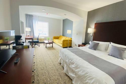 una camera d'albergo con un grande letto e un soggiorno di La Quinta by Wyndham Reynosa a Reynosa