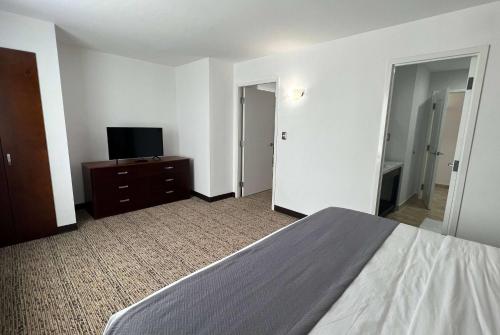 a bedroom with a bed and a flat screen tv at La Quinta by Wyndham Reynosa in Reynosa