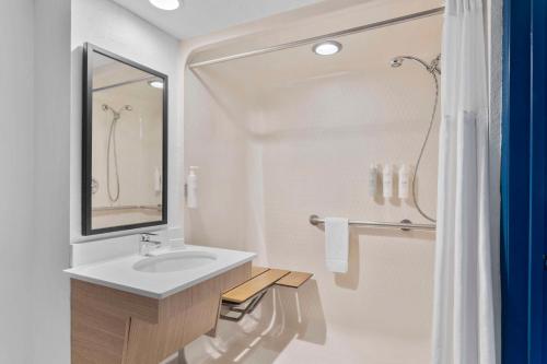 a white bathroom with a sink and a shower at Spark by Hilton Orlando near SeaWorld in Orlando