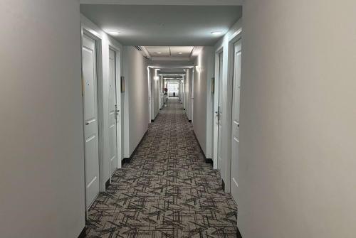 a long hallway with white walls and a patterned floor at La Quinta by Wyndham Reynosa in Reynosa