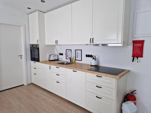 a kitchen with white cabinets and a wooden counter top at MainStreet20 in Stykkishólmur