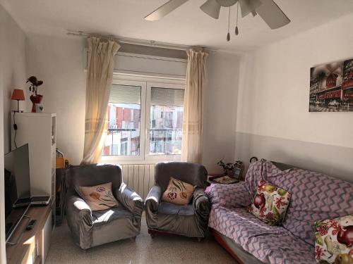 a living room with two chairs and a couch at Habitacion acogedora en Portbou in Portbou