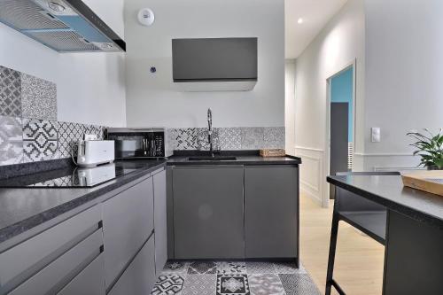 une cuisine avec un évier et un micro-ondes dans l'établissement Appartement de Standing pour 6 refait à neuf, à Lyon