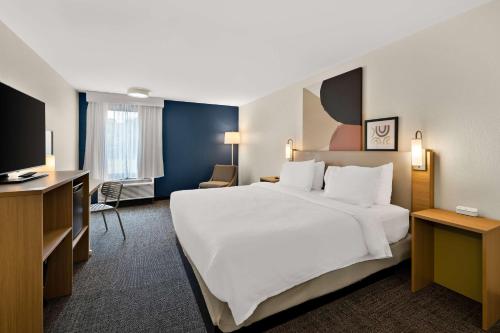 Habitación de hotel con cama grande y TV en Spark By Hilton Tifton, en Tifton