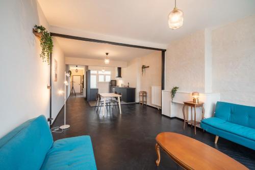 a living room with a blue couch and a table at Charming and Spacious Apartments in the Heart of Antwerp in Antwerp