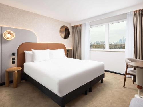 een hotelkamer met een groot bed en een raam bij Mercure London Earls Court in Londen
