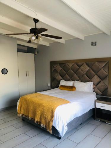 um quarto com uma cama grande e uma ventoinha de tecto em Elihle Guest house em Empangeni