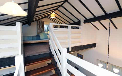a room with stairs and bunk beds in a house at Sparrows Nest Holiday Cottage in Amroth