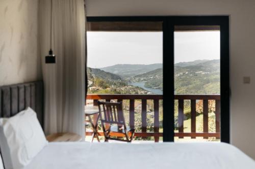 - une chambre avec un lit et un balcon avec vue dans l'établissement Quinta do Bento, à Vieira do Minho