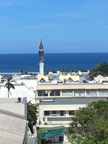 a building with a clock tower on top of it at Lodge Tamarins in Saint-Pierre