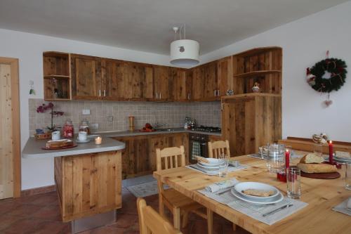 a kitchen with wooden cabinets and a wooden table at Le Dimore Dei Begai in Massimeno