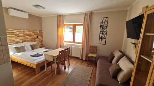 a living room with a bed and a table and a couch at Bakonyi Kiscsillag in Bakonybél