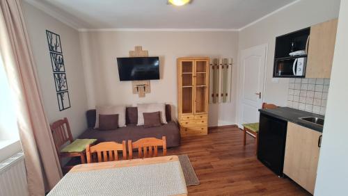 a small living room with a couch and a kitchen at Bakonyi Kiscsillag Bakonybél in Bakonybél