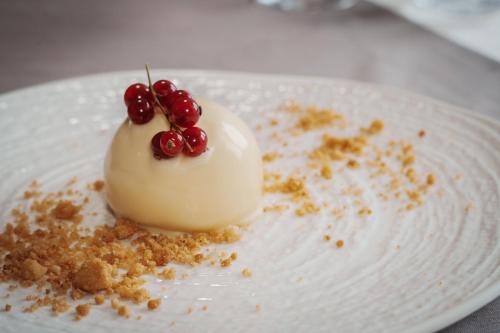 un postre blanco con cerezas en un plato blanco en Villa Tuscolana, en Frascati