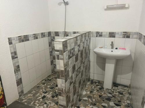 a bathroom with a sink and a tiled floor at KEUR Junior in Ndangane