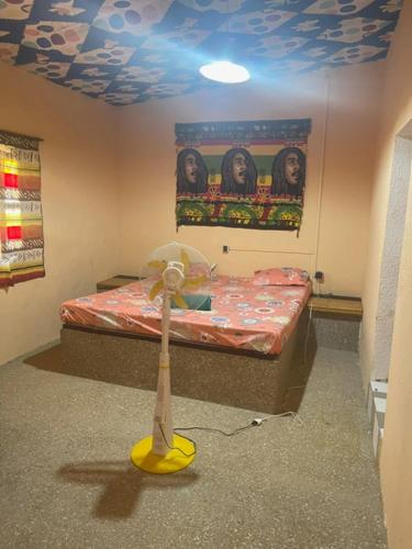 a room with a small bed with a yellow propellor at KEUR Junior in Ndangane