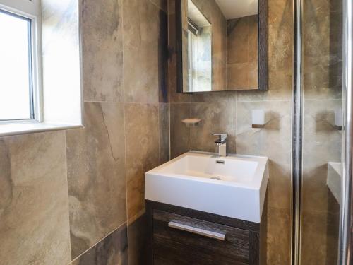 a bathroom with a white sink and a shower at 5 Emmott Court in Colne