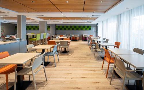 a dining room with tables and chairs in a cafeteria at Kyriad Prestige Saint-Malo in Saint Malo