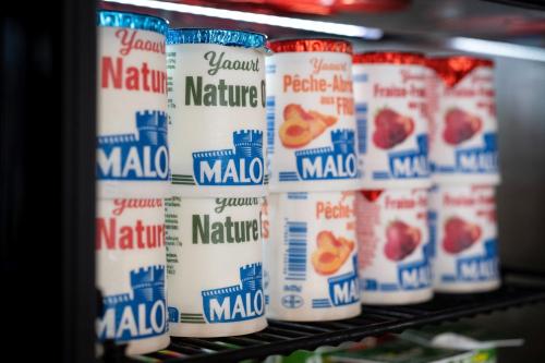 a row of milk cans on a shelf in a store at Kyriad Prestige Saint-Malo in Saint Malo