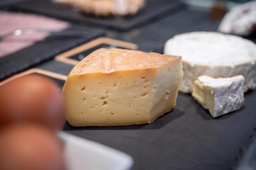 a block of cheese on a table with other cheeses at Kyriad Prestige Saint-Malo in Saint Malo
