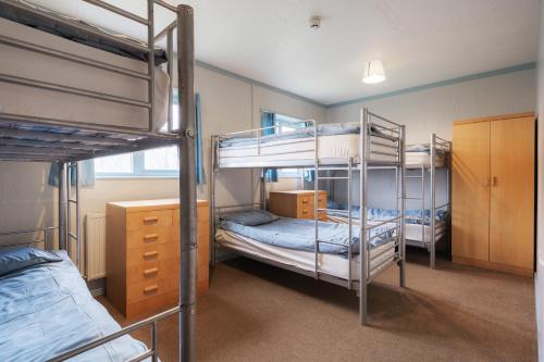 Zimmer mit 3 Etagenbetten und einem Schreibtisch in der Unterkunft Stunning Rural 72 bed bunkhouse 21 Bedrooms in Elerch